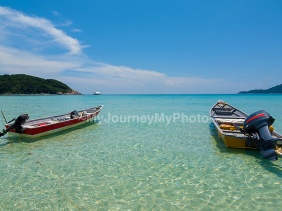 Boats on a clear water and blue sky at Perhentian Kecil Island, Malaysia